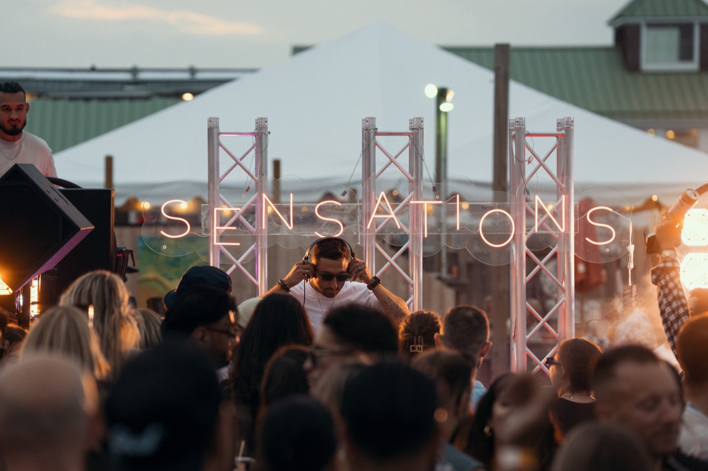 The Sensations sign over the crowd at golden hour, Hideaway